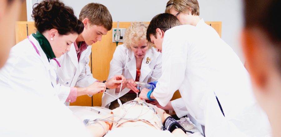 Students practice emergency medical procedures on SimMan, which simulates real symptoms. Photo: Stephanie Greenwood