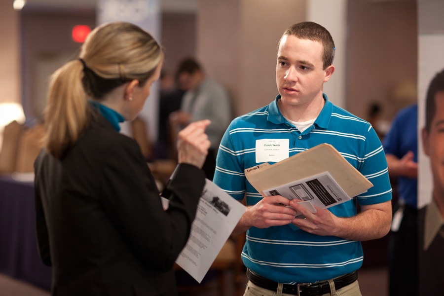 2012 criminal justice graduate Caleb Watts speaks with a representative at the Career Fair. Photo: Photo Services