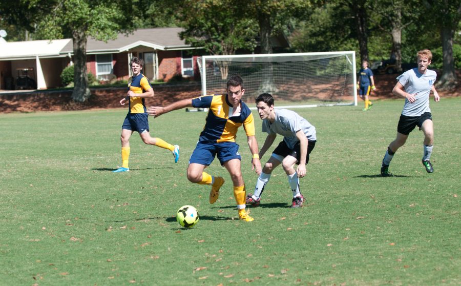Omega’s Vince Wilson keeps the ball a safe distance from a Beta defender. Photo: Holly DIller