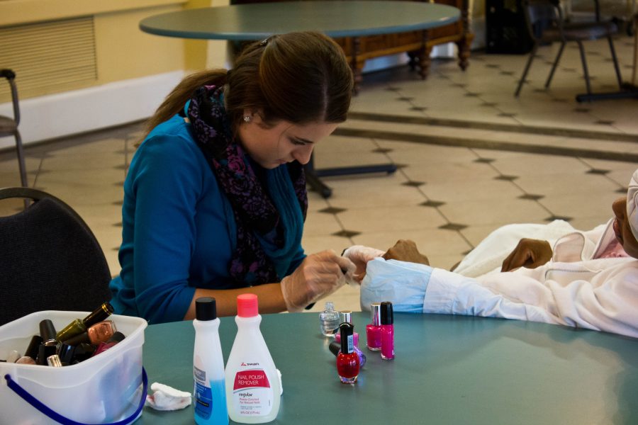 Bethany Pursel provides a manicure and good conversation for a resident at Laurel Baye Healthcare. Photo: Ethan Rogers