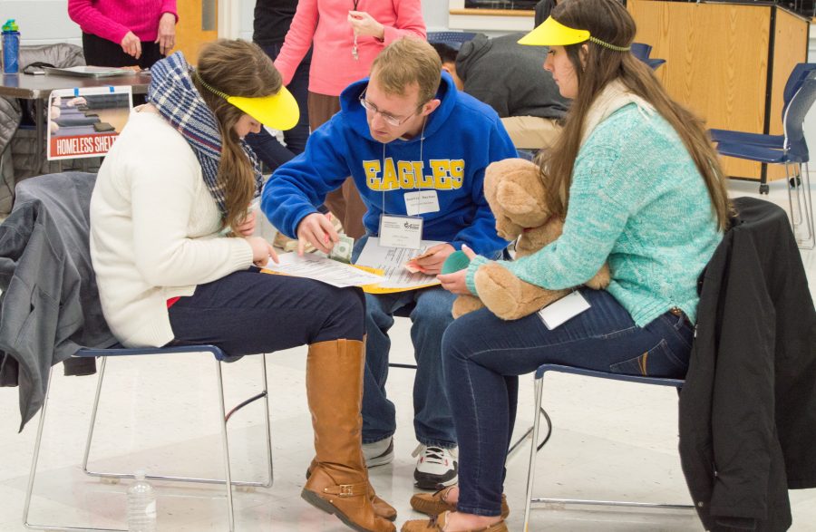 Students look over the specifics of what they are going to have during the poverty simulation in the Applied Studies building at Bob Jones. Photo by Rebecca Snyder. 30.15
