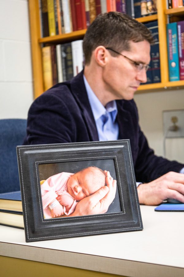 Cook works in his office beside a family photo. Photo: Andrew Pledger
