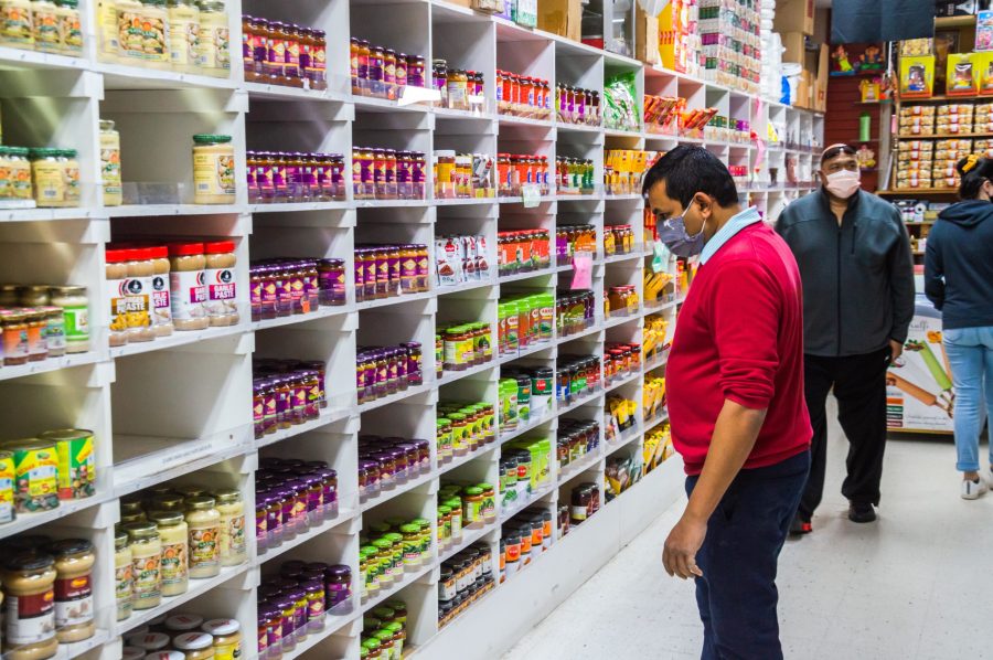 Manager Patel searches for a product in the aisles of his store.
Photo: Heath Parish