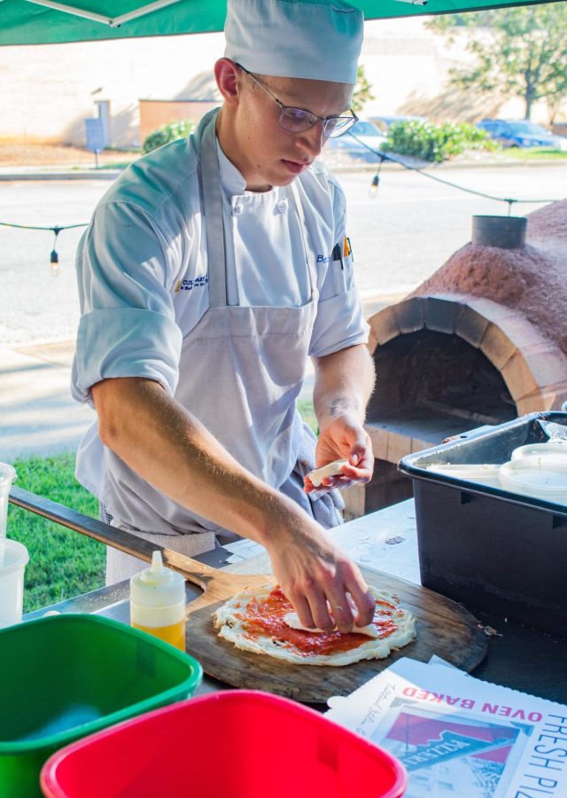 Joe Beach, a sophomore culinary arts student, prepares pizza using the Bistros new clay oven.
Photo: Robert Stuber