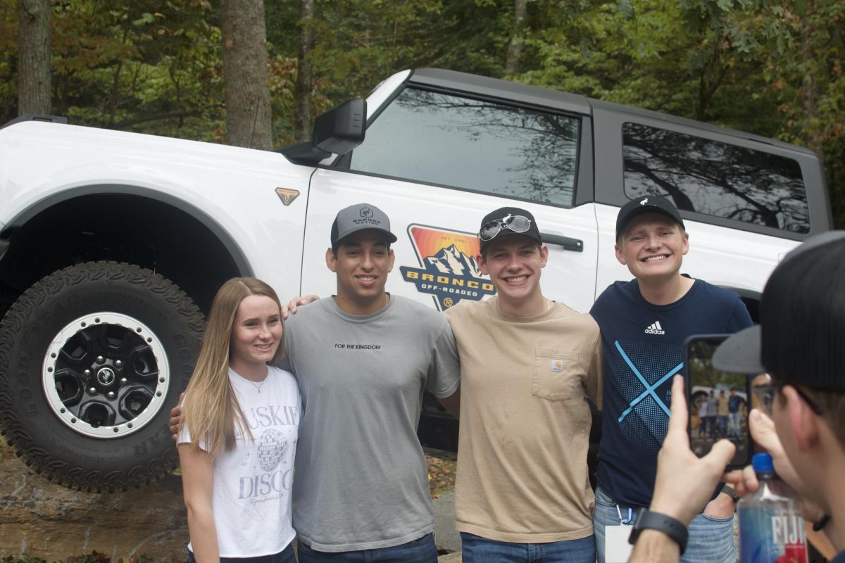 Jordan Meyer (left), a senior business administration major, Joan Gracia Nunez (middle left), a junior business administration major, Wesley Gay (middle right), a junior accounting major, and Andrew Dubberly (right), a senior business administration major, having their picture taken by Adam Banks.