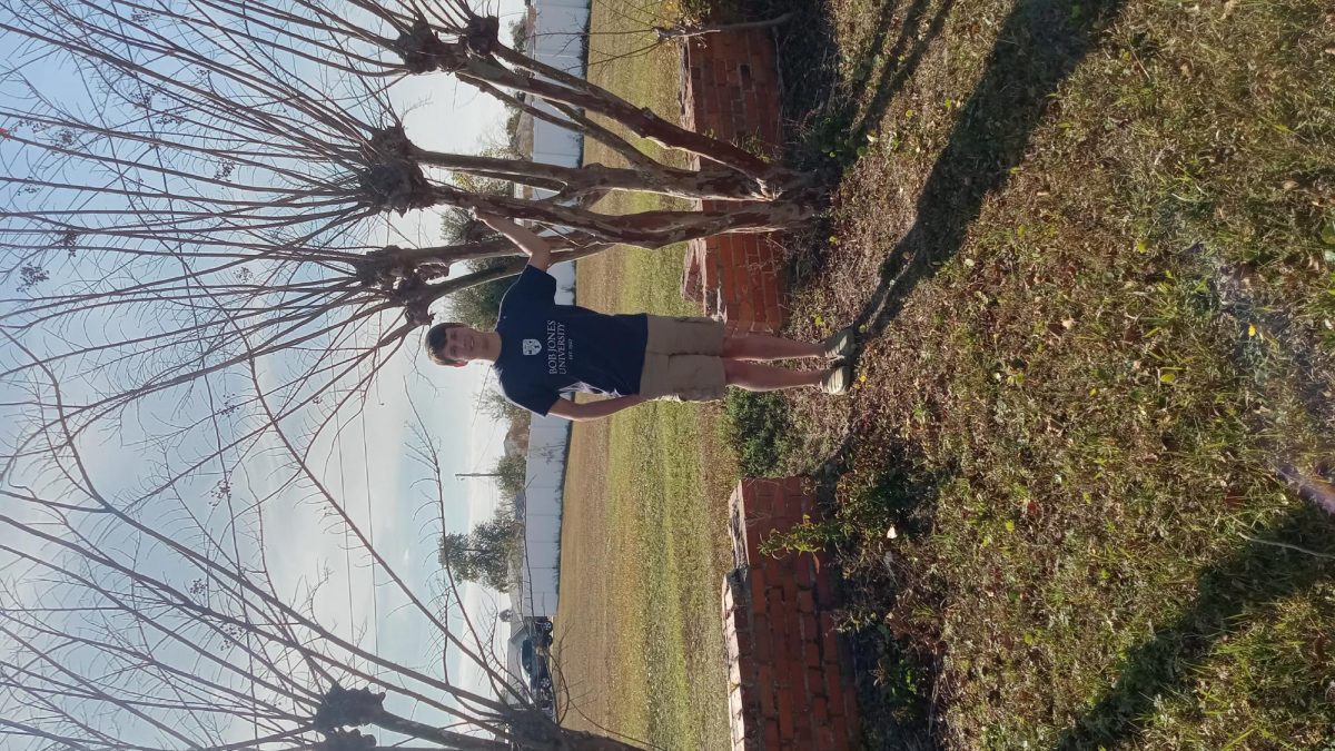 The reporter standing next to the wall.