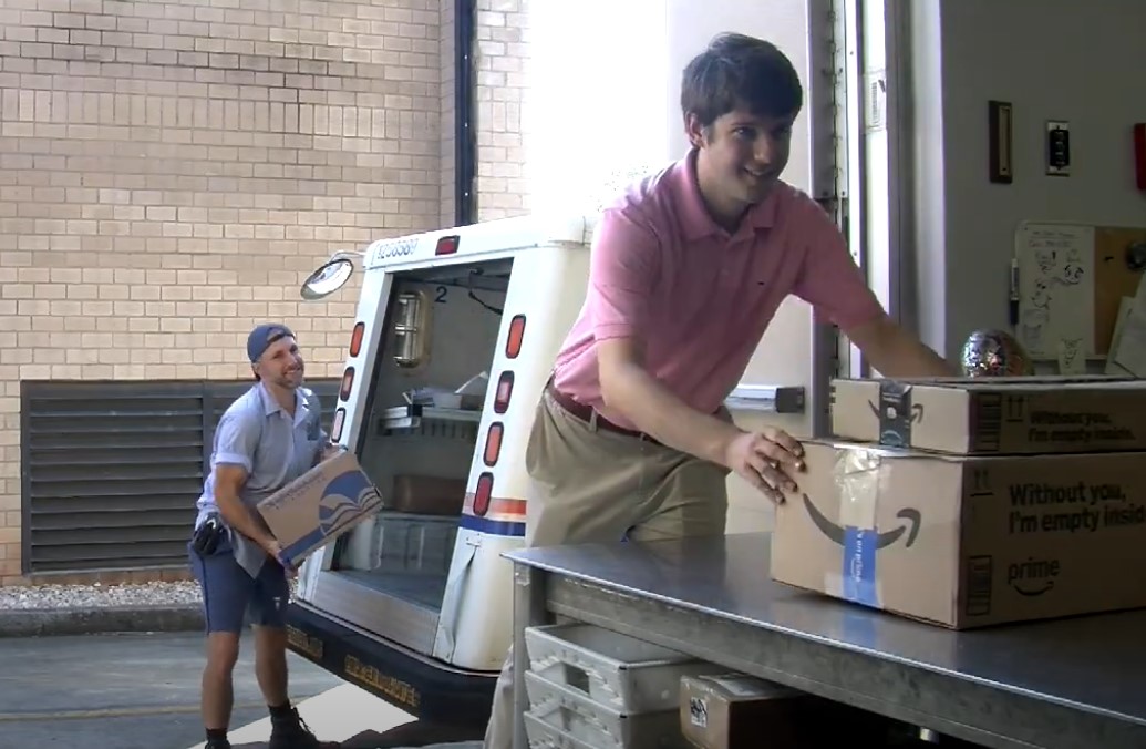 Collegian reporter (and part-time post office employee) Zachary Edmondson unloads packages at the post office location on the BJU campus. Photo provided. 