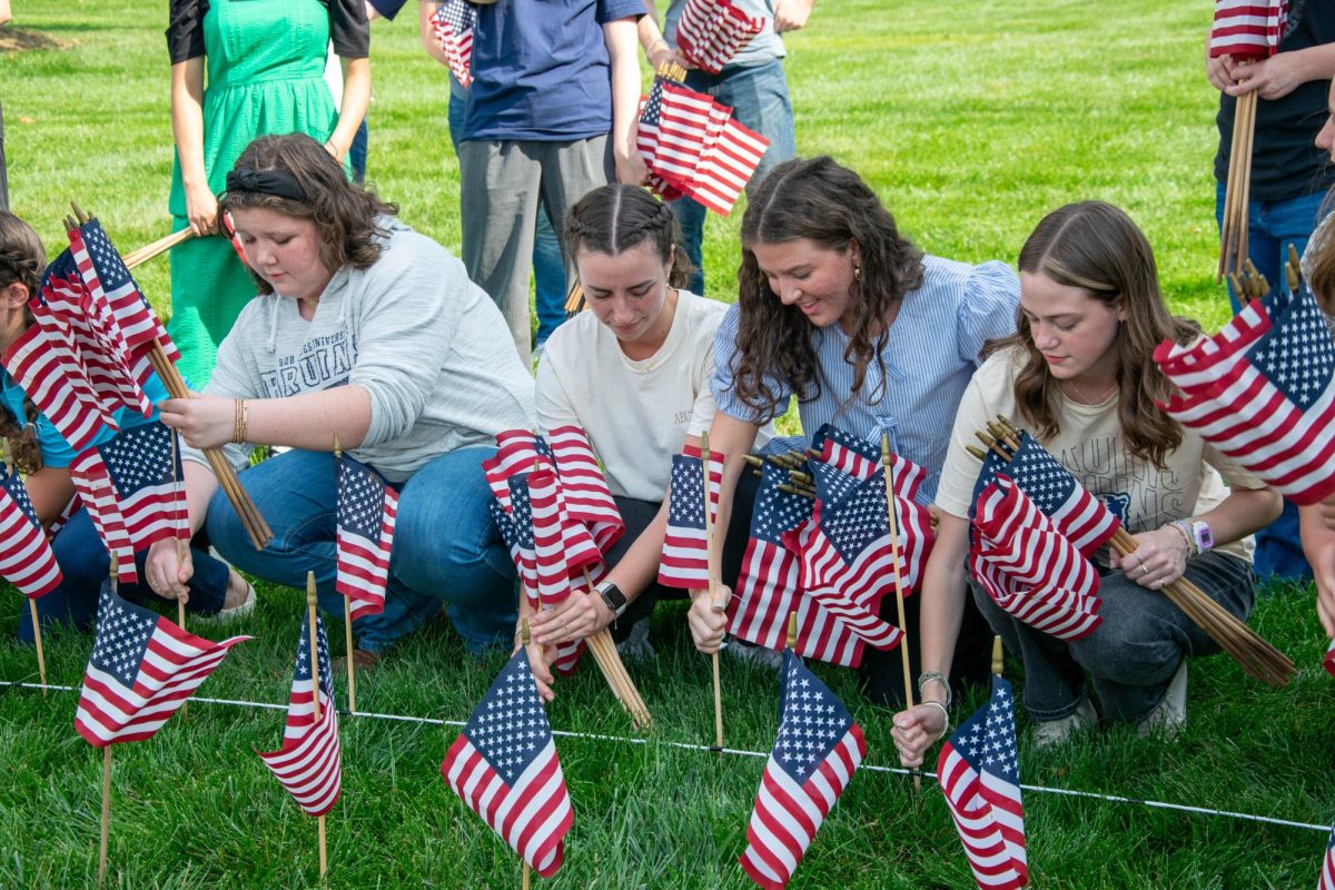 Students place flags along Wade Hampton Boulevard on either side of the main entrance to Bob Jones University in remembrance of the 2,977 victims of the Sept. 11, 2001 terror attacks. Jacquelyn Lilyea/STAFF