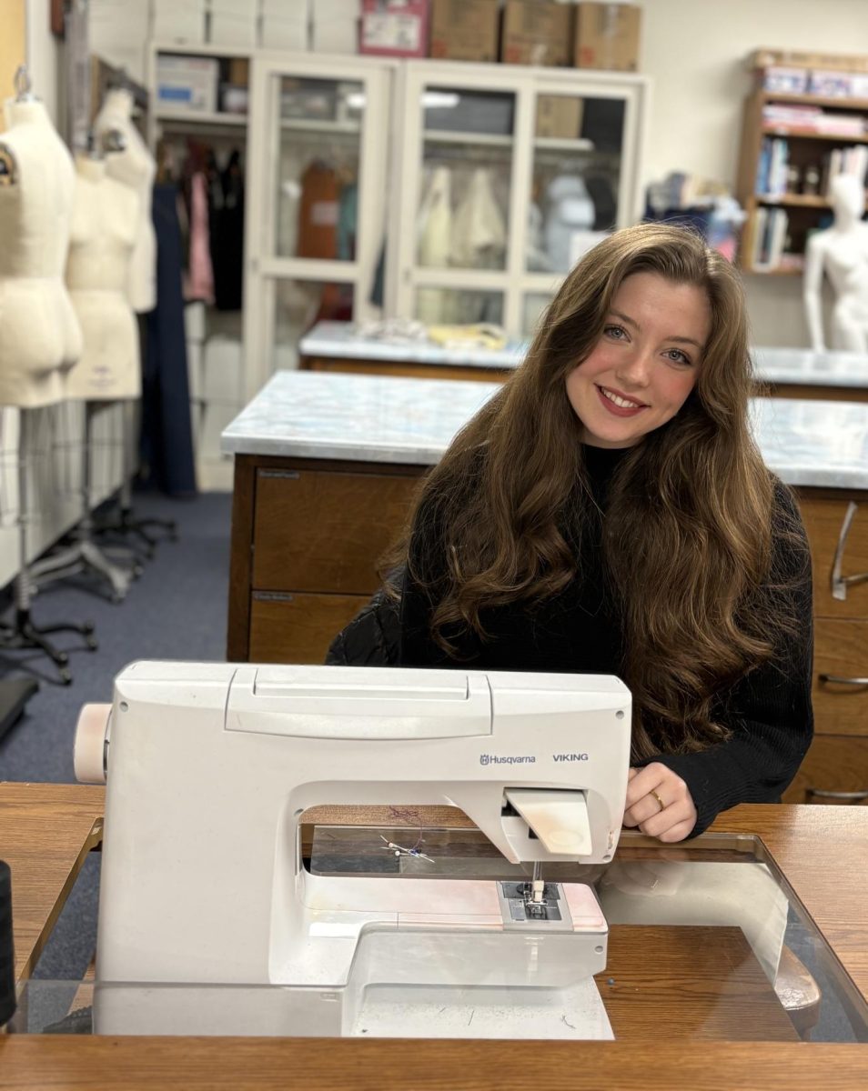 Isabella Marchak sits at one of the sewing machines in an apparel workshop.
