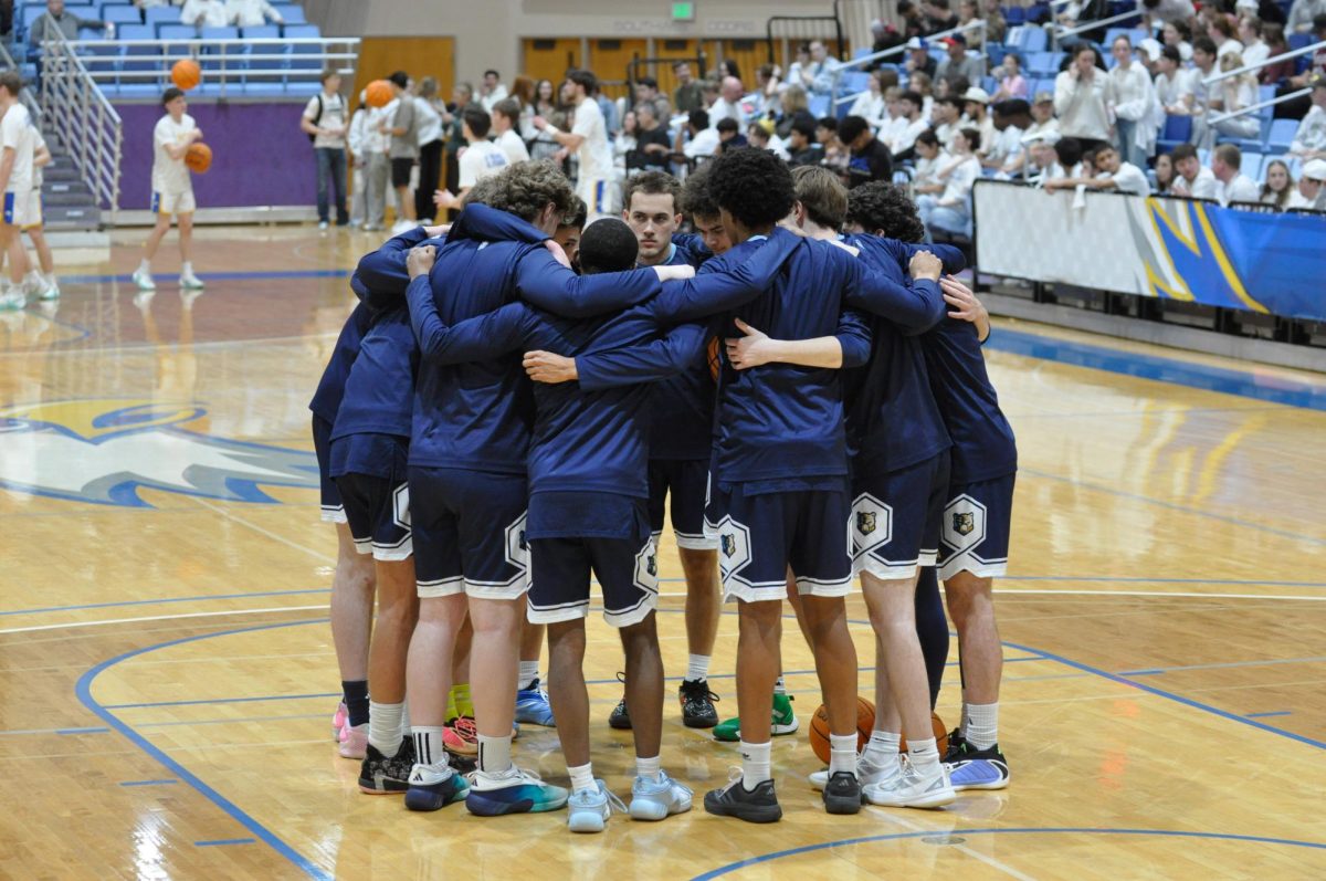 The men's team huddles before the game at PCC.