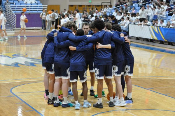The men's team huddles before the game at PCC.