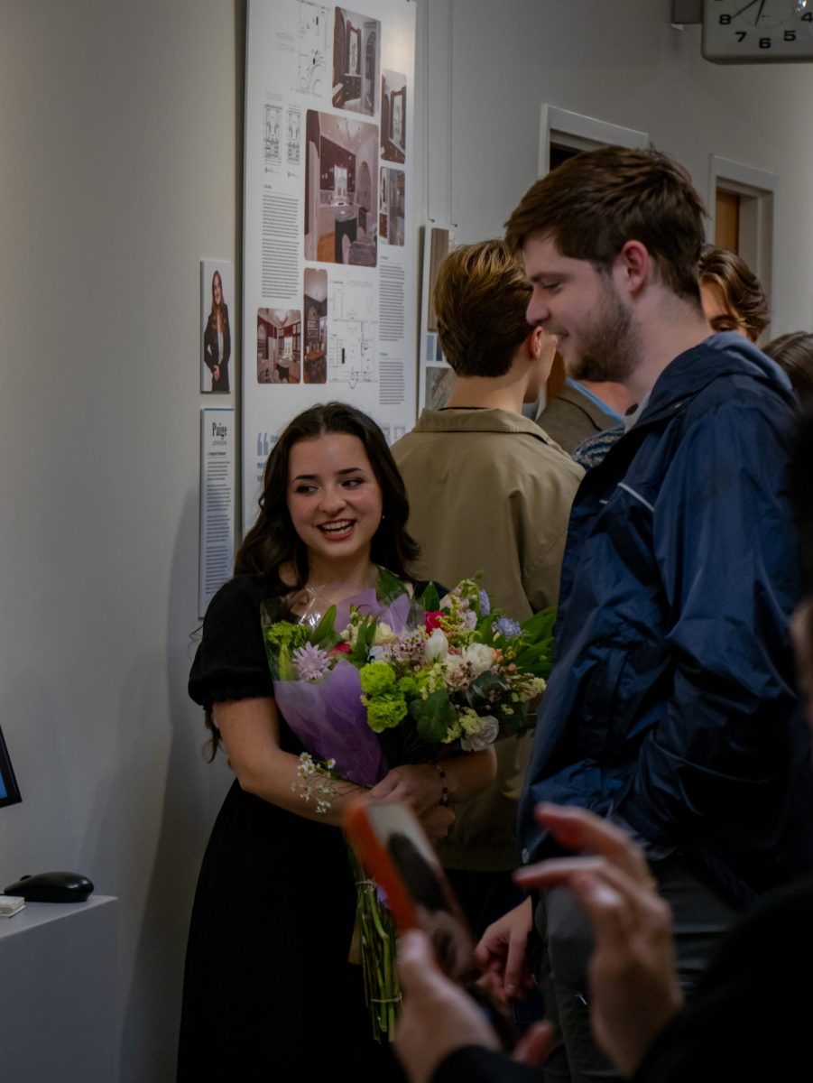 Maddie DeJesus, a senior graphic and digital design major, presents her portfolio to guests.