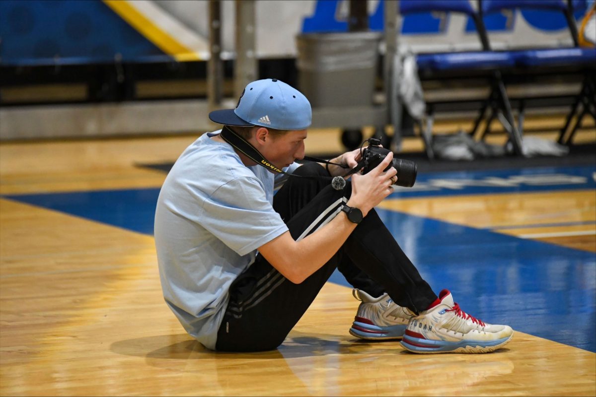 Daniel Kyle, junior multimedia journalism major, shooting a Bruins' basketball game.